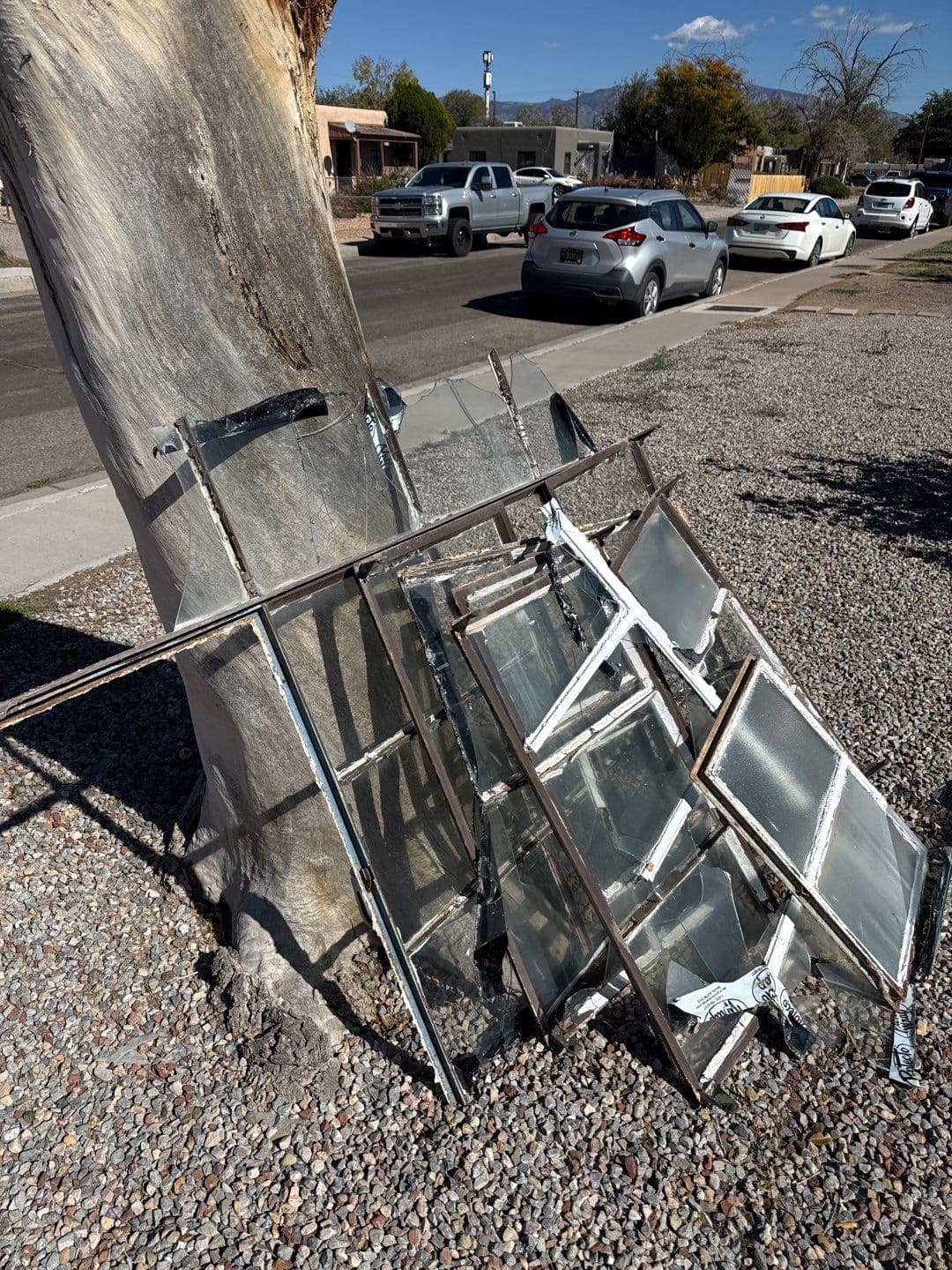 During the install — old steel-frame windows removed from the home and stacked on the curb for disposal